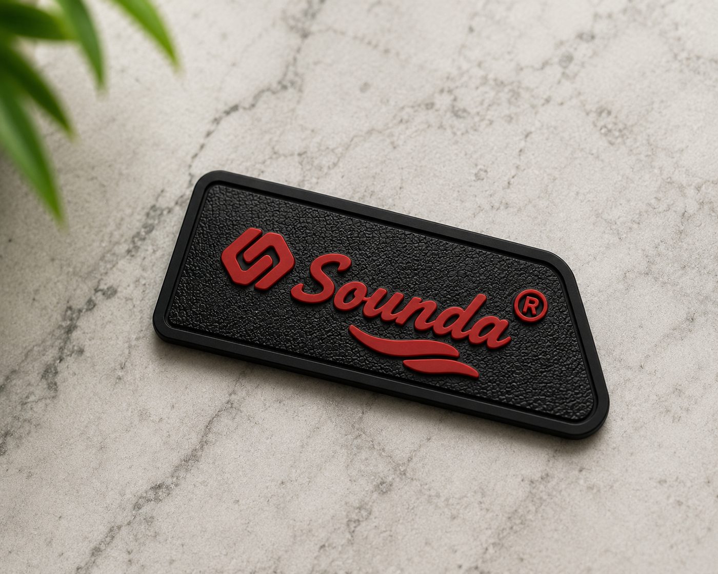 Sounda raised-logo rubber label in black